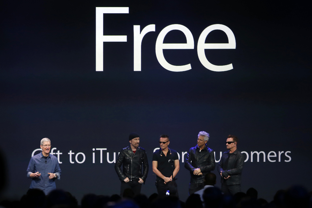 Apple CEO Tim Cook stands with Irish rock band U2 as he speaks during an Apple event announcing the iPhone 6 and the Apple Watch at the Flint Center in Cupertino